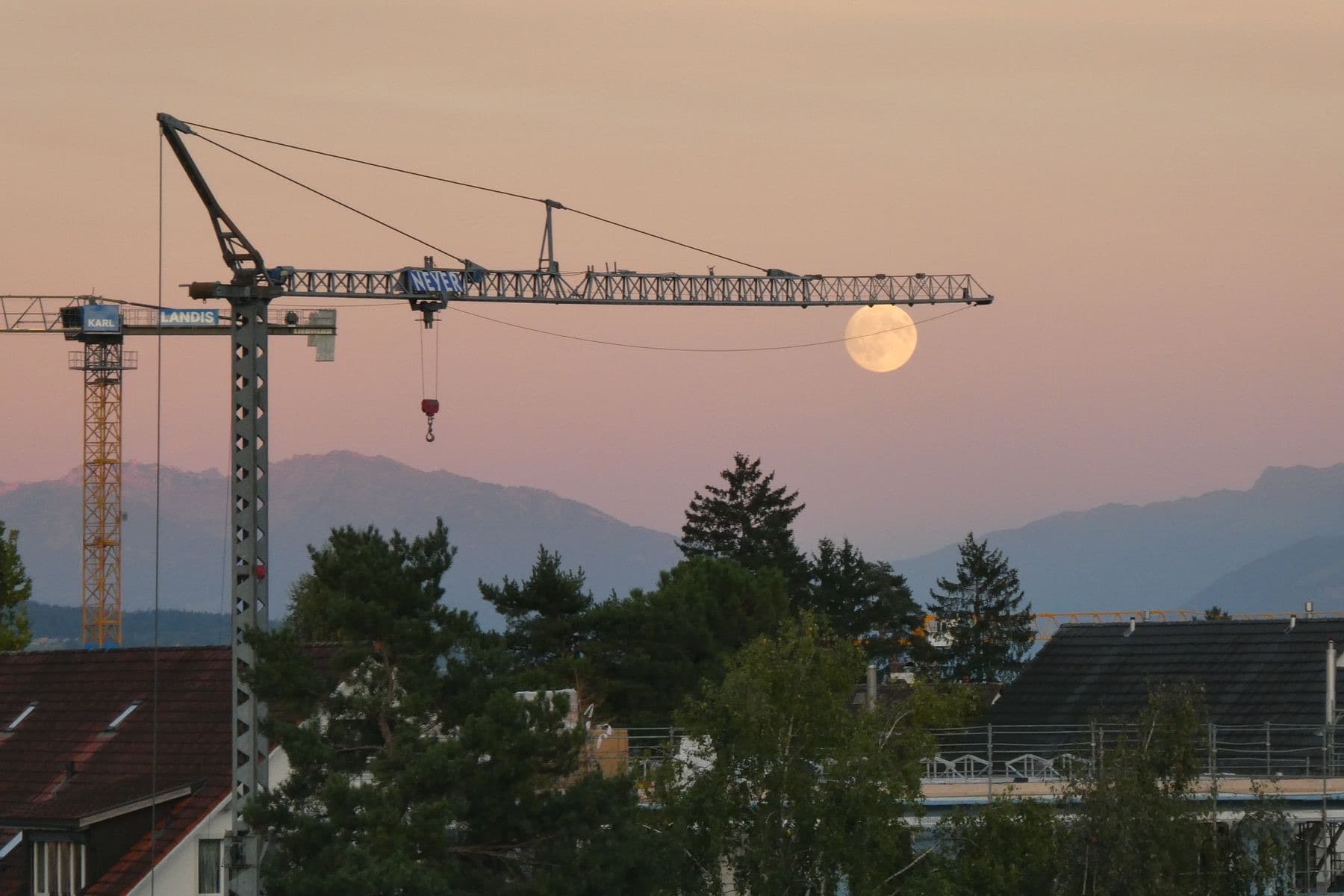 A tower crane against the moon. The long climb from 15 acquisitions to 10,000 deals.